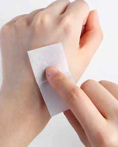 Close-up of a person using a sterile alcohol prep pad for skin cleansing and disinfection before a medical injection.