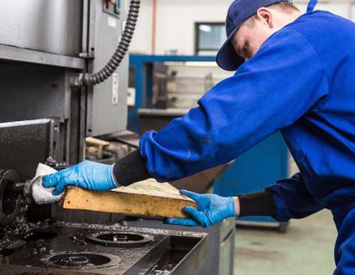 Industrial worker using heavy-duty degreasing wipes for machinery maintenance and workshop equipment cleaning