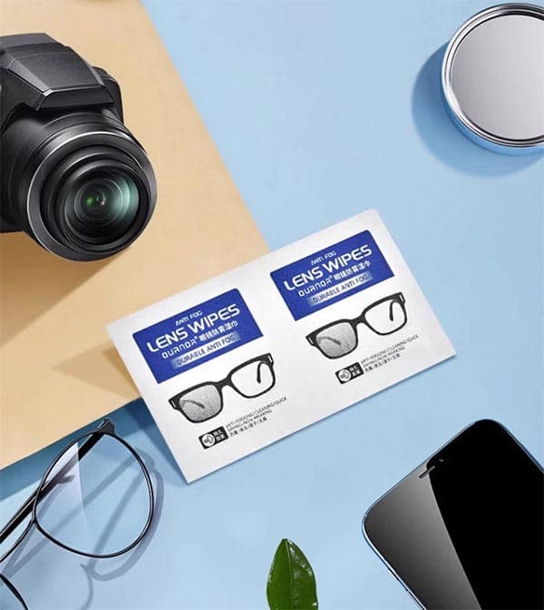 Custom pre-moistened lens wipes cleaning a professional camera lens