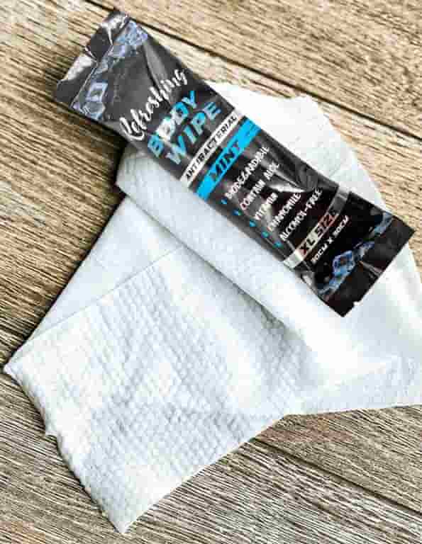 An individually wrapped XL size refreshing body wipe on top of a textured spunlace nonwoven fabric, engineered for travel, camping, and outdoor sports use.