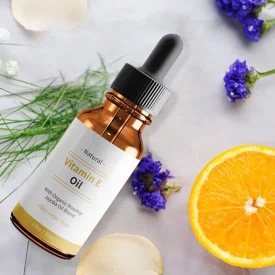 Amber dropper bottle of natural vitamin E oil with an orange slice for private label cosmetic wet wipes production.